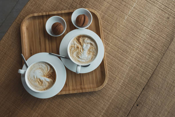 istock White cup with hot coffee drink and dessert on a tray on a wooden table 2205854496