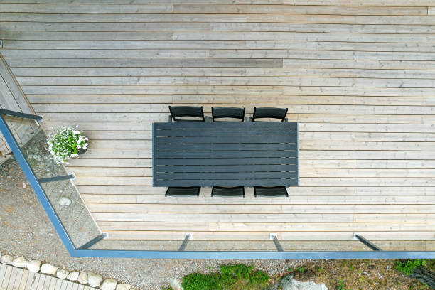 istock Modern outdoor dining table with black chairs on wooden deck 2205861307