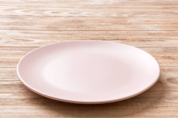 istock Perspective view of empty pink plate on wooden background. Empty space for your design 2205867119