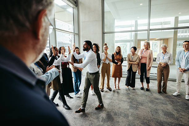 istock Boss celebrating with employees giving high fives in a modern office setting 2205867403