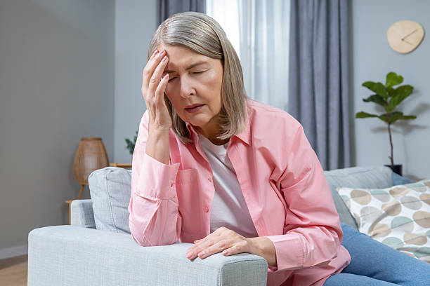 istock Mid aged woman suffering from a headache and looking exhausted 2205868661