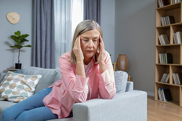 istock Mid aged woman suffering from a headache and looking exhausted 2205868662