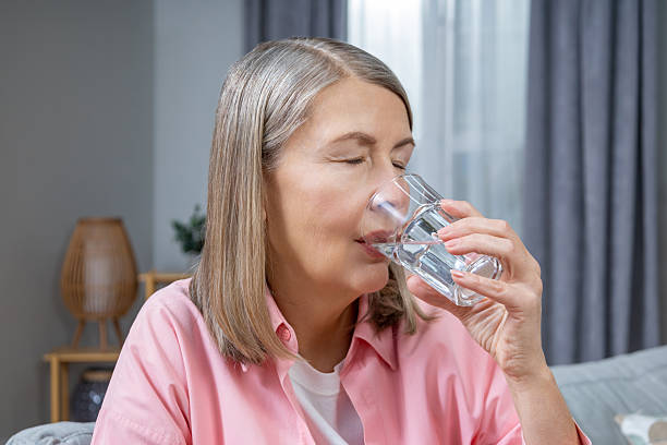 istock Mid aged woman feeling unwell and taking pills 2205868705