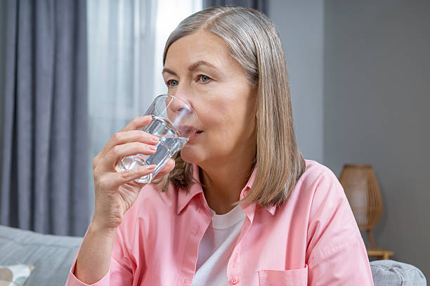 istock Mid aged woman feeling unwell and taking pills 2205868712