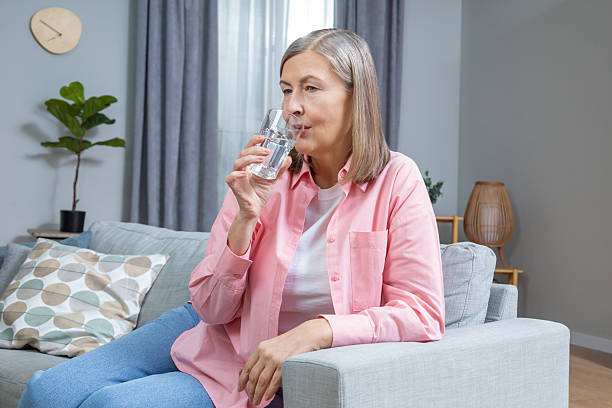 istock Mid aged woman feeling unwell and taking pills 2205868737