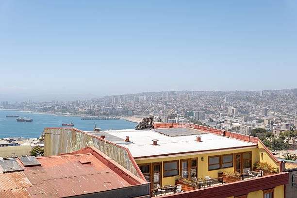 Vibrant rooftop with ocean view in a bustling coastal city. Sunlit day over urban landscape and waterfront.