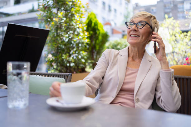 istock Smiling senior on phone with coffee 2205871953