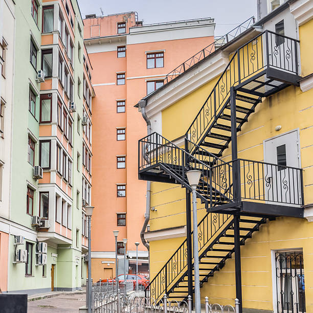 Multi-colored building facades. Metal fire escape on a yellow wall.