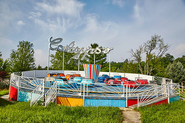 Colorful Vintage Calypso Amusement Ride with Lush Greenery Background Vintage Calypso amusement ride in vivid colors abandoned at Fun Spot, Indiana, surrounded by lush greenery under a blue sky, 2015 abandoned roller coaster stock pictures, royalty-free photos & images