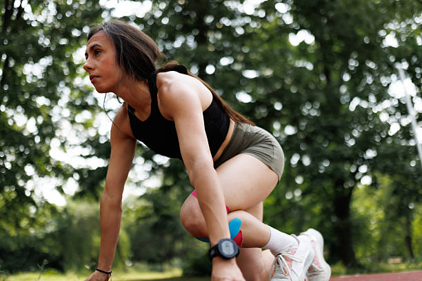 istock Young woman in outdoor setting preparing for a run with knee support 2205879283