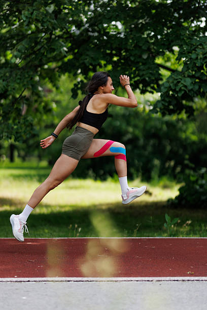 istock Athletic woman performing a dynamic exercise outdoors on a running track in a park setting, showcasing strength and agility during a workout session 2205879407