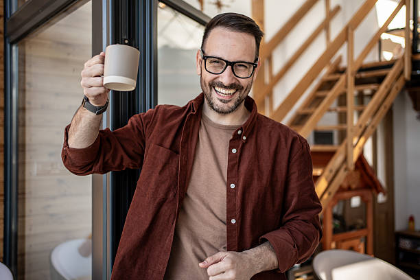 istock Smiling freelancer raising coffee mug in home office 2205881466
