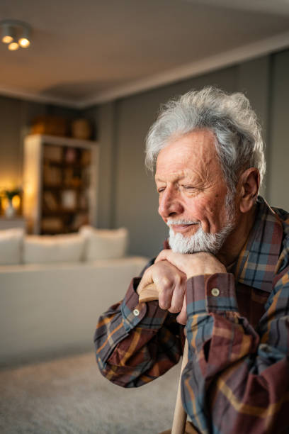 istock Senior man smiling and holding a cane at home 2205884417