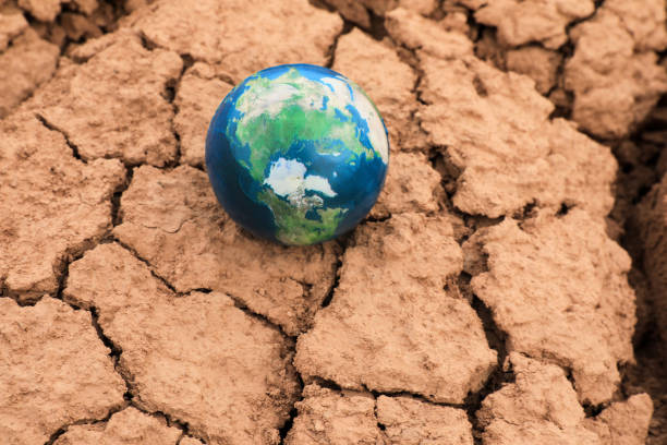 istock Earth planet on cracked earth background. Global warming and climate change concept. 2205887615