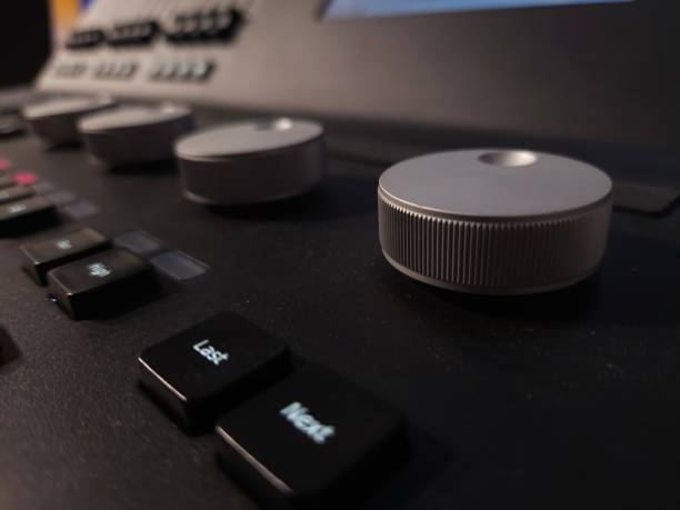 istock Close-up of a professional lighting control panel with illuminated buttons, rotary dials, and a dark keyboard. 2205888225