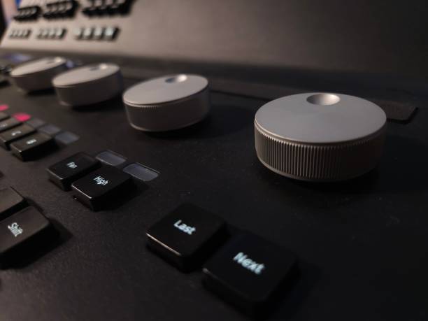istock Close-up of a professional lighting control panel with illuminated buttons, rotary dials, and a dark keyboard. 2205888238