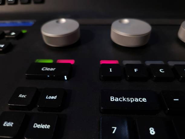 istock Close-up of a professional lighting control panel with illuminated buttons, rotary dials, and a dark keyboard. 2205888343