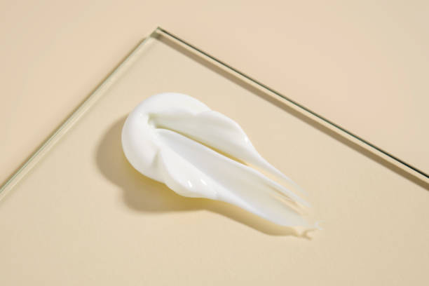 istock A smear of white cream on a beige background. 2205888408