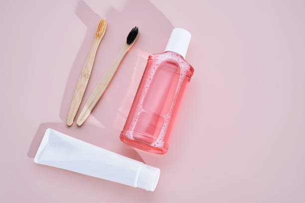 istock Pink mouthwash, toothpaste and toothbrushes on a pink background. 2205888552