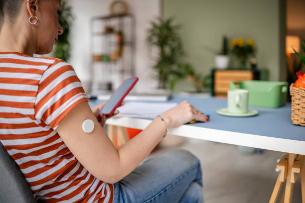 istock Young woman with type 1 diabetes managing her health at home using a continuous glucose monitor and a mobile device 2205888607