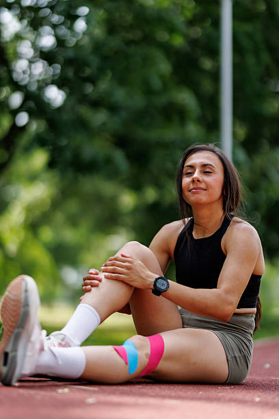 istock Woman Stretching Outdoors on Track During Exercise with Kinesiology Tape 2205888688
