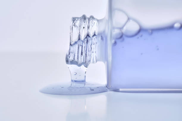 istock A cosmetic bottle from which a blue emulsion is poured. 2205888925