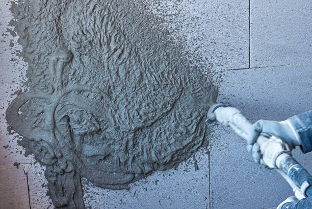 istock Plasterer using and operating sprayer mortar equipment machine for spraying mortar wall and plastering for the decoration finishing work at the construction site 2205889032