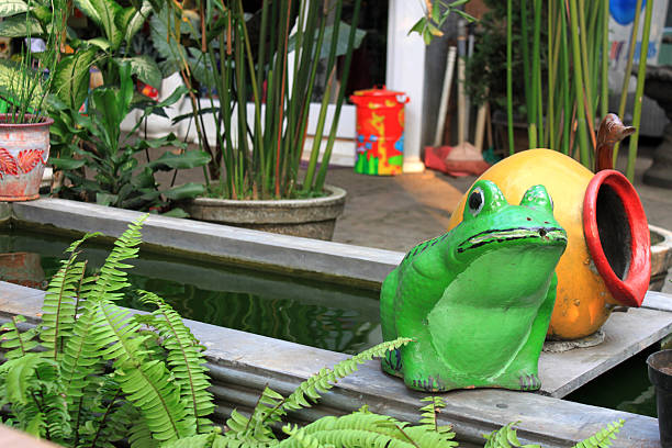 frog statue on the edge of the fish pond