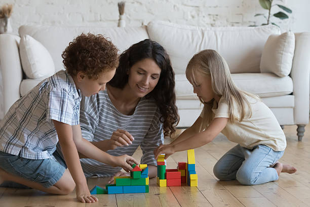 istock Happy mom and two little kids playing on heating floor 2205891491