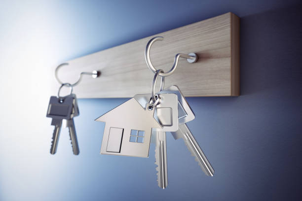 istock Key chain with keys hanging on wooden keyboard 2205891710