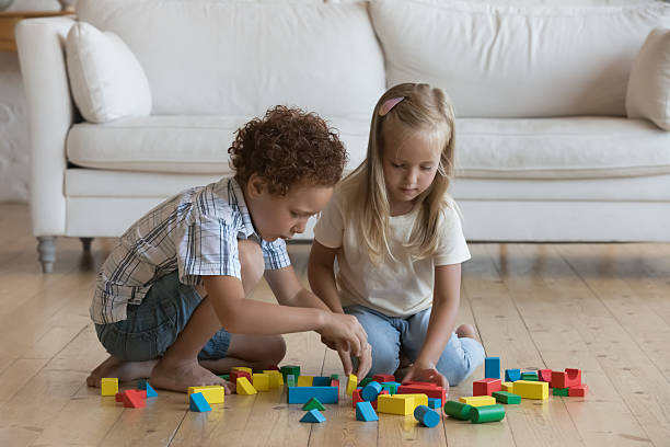 istock Two focused little kids playing on floor at home 2205892368