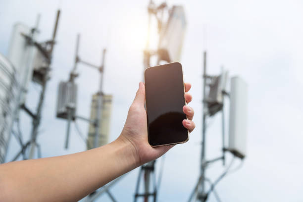 istock Human hand using mobile phone near 5G communications tower 2205894292