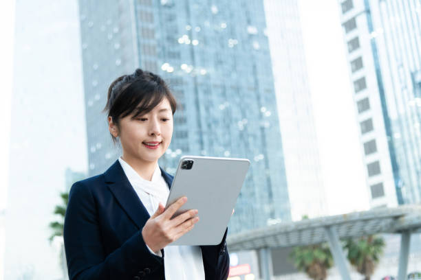 istock Businesswoman using digital tablet outside the office building 2205894726