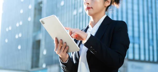 istock Businesswoman using digital tablet outside the office building 2205894751