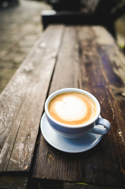 Cappuccino on rustic wooden table in outdoor cafe