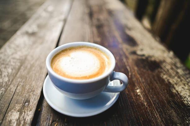istock Steaming cup of cappuccino on rustic wooden table 2205895285