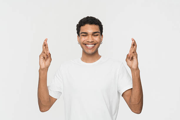 istock Smiling Young Man With Crossed Fingers in a Positive Gesture 2205895575