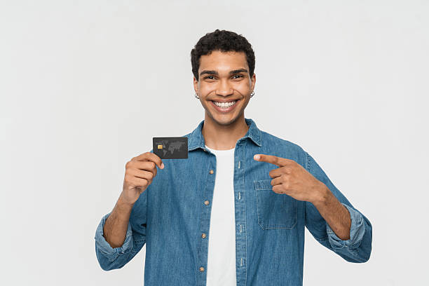 istock Smiling Person Displaying a Credit Card in a Studio Setting 2205895696