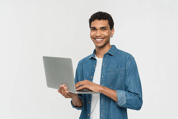 istock Smiling Young Man Using Laptop Against White Background 2205895793