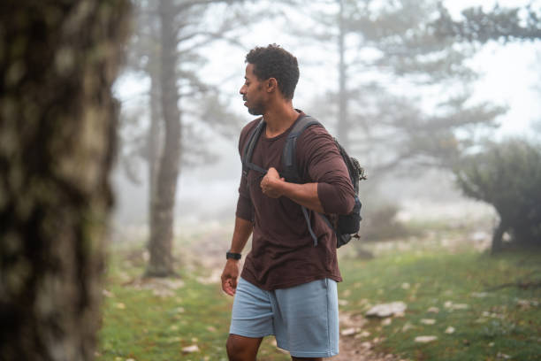 istock Focused Black Male Hiker Exploring Misty Forest in Casual Attire 2205896609