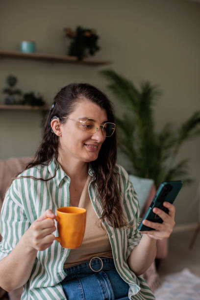 istock Woman Checking Phone While Sitting at Home 2205901920