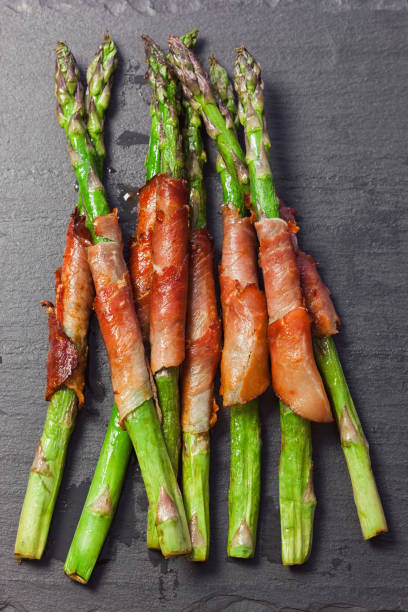 istock Fresh green asparagus wrapped in prosciutto 2205902891