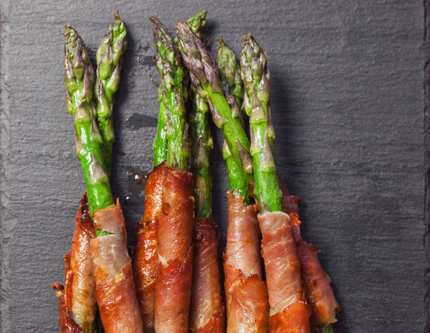 istock Fresh green asparagus wrapped in prosciutto 2205902922
