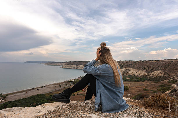 istock Young Woman Enjoying Peaceful Coastal View from a Cliff 2205905028