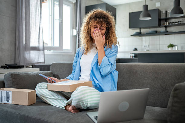 istock Disappointed young woman opening a parcel at home 2205905401