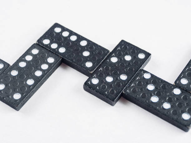 istock Dominoes arranged for a game. The tiles are black with white dots a classic pattern-rich image. 2205906063