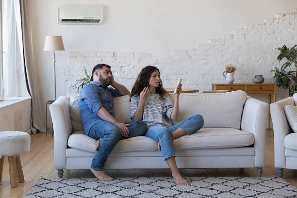istock Frustrated adult millennial couple having problems with air conditioner start 2205909799