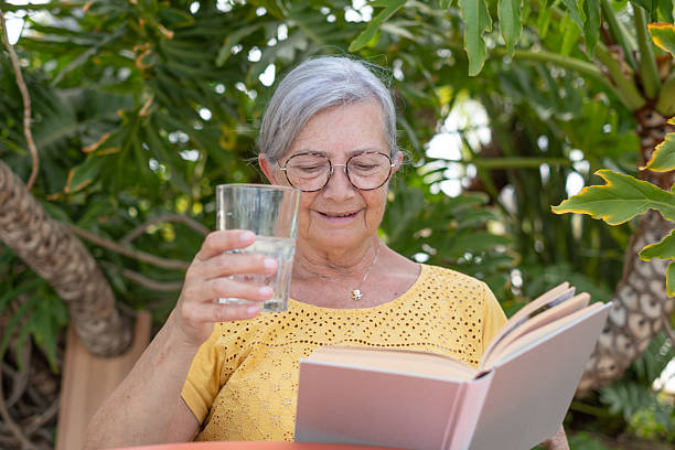 istock Mature elderly woman enjoys a peaceful moment reading a book outdoors. The image captures a blend of tranquility, self-care, and intellectual engagement in a natural setting. 2205914516