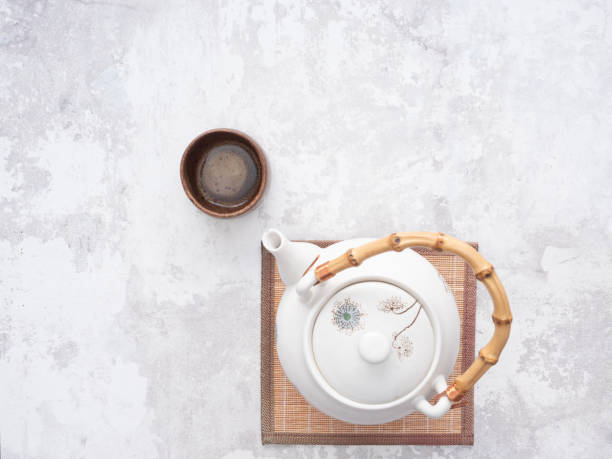 istock Asian teapot with bamboo handle and teacup on table 2205915835
