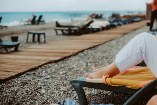People sunbathing on a sandy beach, enjoying the warm weather. Strong UV rays increase the risk of skin cancer, highlighting the importance of sunscreen and sun protection.
